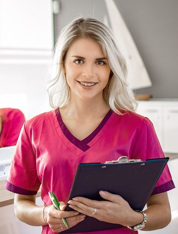 Zahnmedizinisches Fachpersonal in pinker Praxisbekleidung am Empfang – Symbol für Jobvermittlung und Praxismanagement mit DentiFox.